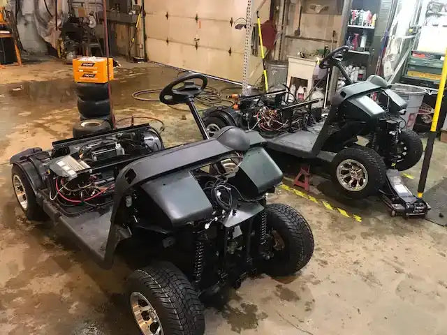 Two disassembled golf carts.