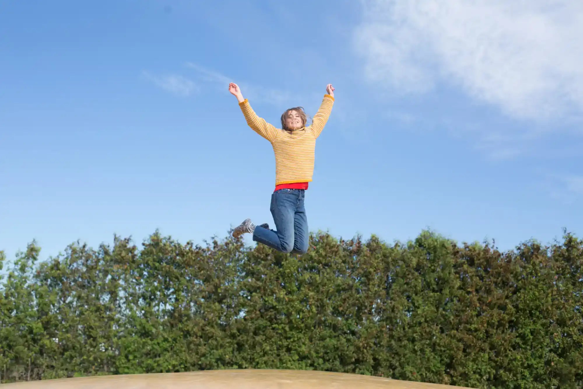 Jumping woman with arms raised.